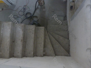 Вид сверху на готовую лестницу с забежными ступенями из бетона