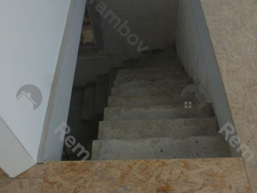 Вид на бетонную лестницу с площадки на втором этажа
